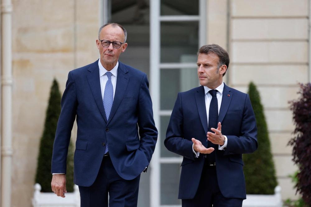 France's President Emmanuel Macron (R) speaks with Germany's Chancellor Friedrich Merz, in Paris. — AFP