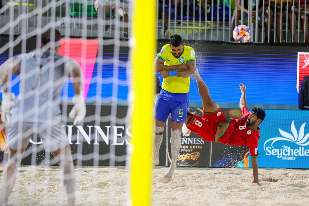 Oman player makes an acrobatic effort.