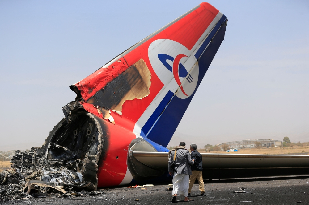 Journalists inspect a destroyed plane on the tarmac at the Sanaa International Airport on Wednesday. - AFP