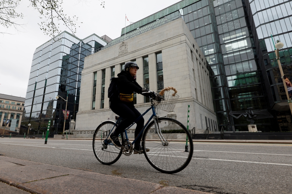 A cyclist rides past the Bank of Canada building in Ottawa, Ontario, Canada. - Reuters