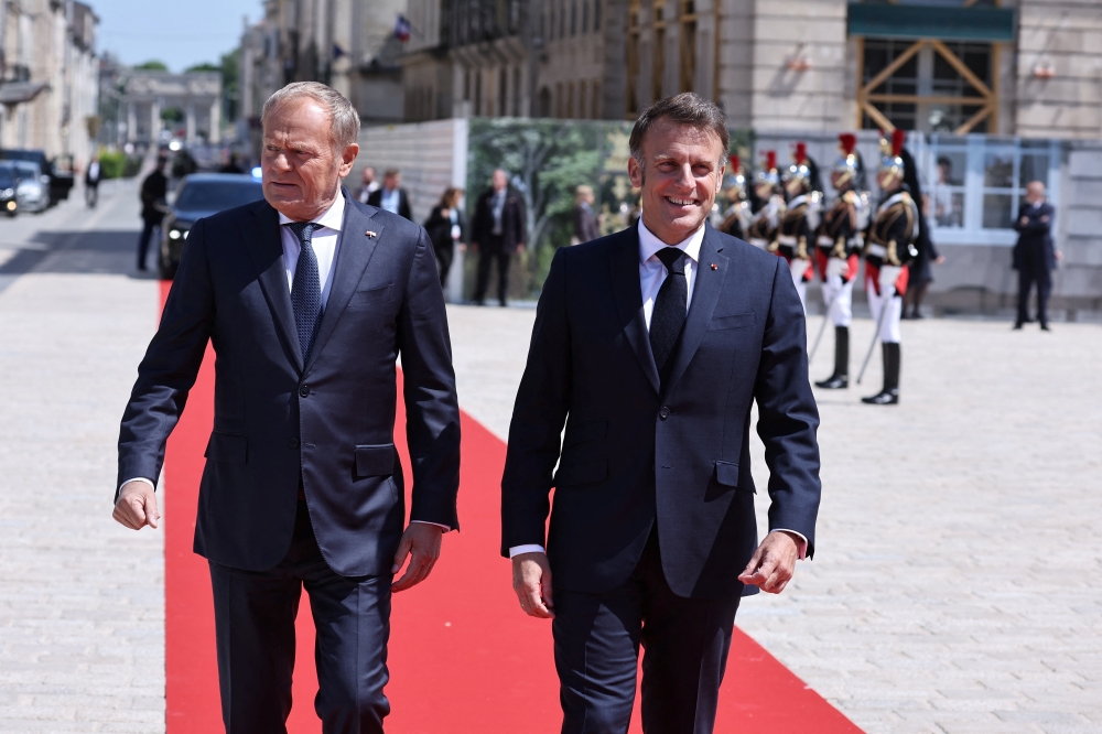 French President Emmanuel Macron (R) and Polish Prime Minister Donald Tusk meet on Stanislas square in Nancy, France. — Reuters
