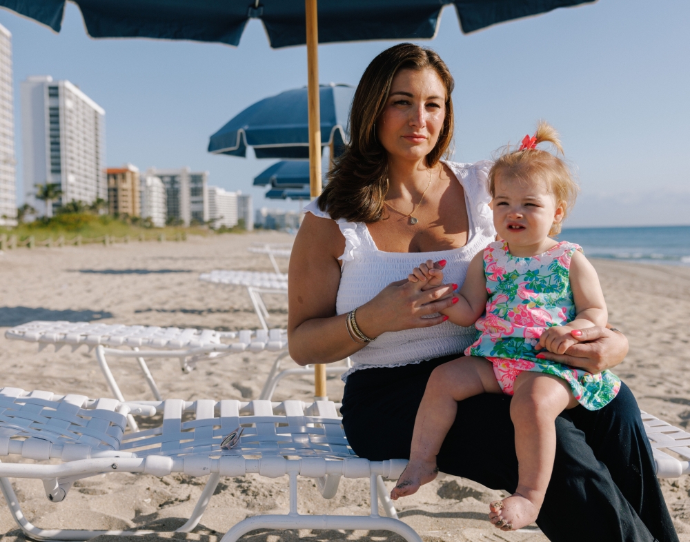 Chelsea Nicholls, who said that because of recent airline disasters and thoughts of what could happen, she now purchases a seat on flights for her 16-month-old daughter instead of holding her, at a beach while visiting family in Boca Raton, Fla., March 22, 2025. (James Jackman/The New York Times)
