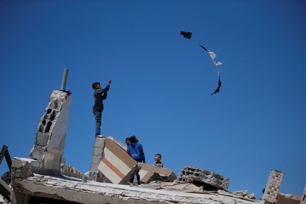 Children play amidst the rubble of houses in Jabalia refugee camp, in the northern Gaza Strip. - Reuters