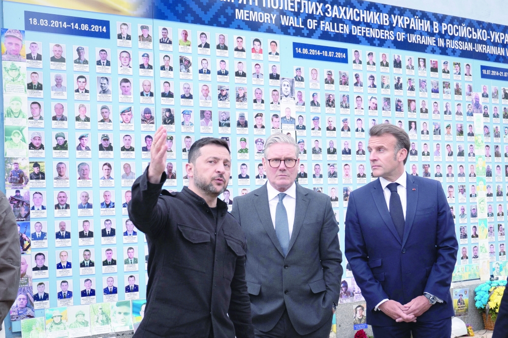 Ukrainian President Volodymyr Zelensky, British PM Keir Starmer and French President Emmanuel Macron visit the Memorial Wall of Fallen Defenders of Ukraine, in Kyiv. — Reuters