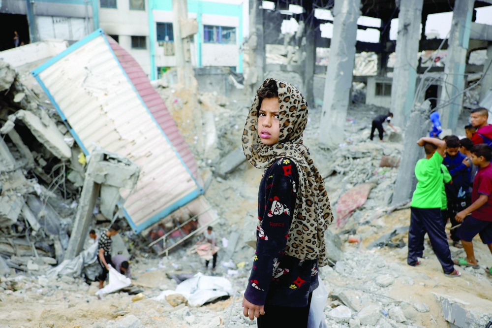 A young Palestinian girl looks amid the rubble