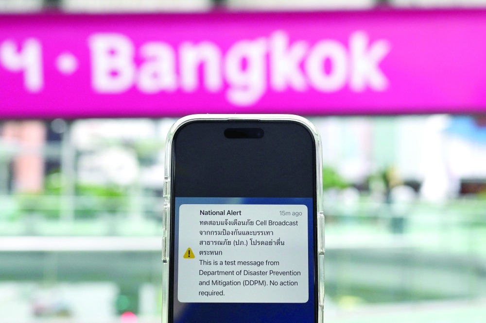 A message from Thailand's Department of Disaster Prevention and Mitigation is pictured on a smartphone during a test run for an emergency cell broadcast system in Bangkok on Tuesday. — AFP