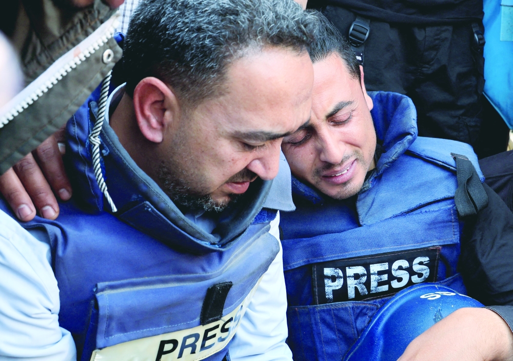 Mourners react during the funeral of Palestinian journalist Hassan Aslih who was killed in an Israeli strike in Khan Younis in the southern Gaza Strip, on Tuesday. — Reuters