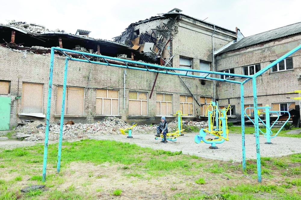 A child sits at a playground near a damaged school in Kramatorsk, Donetsk region. — AFP