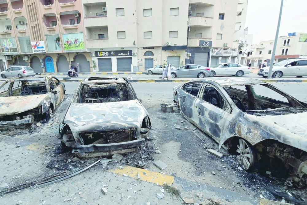 Burnt cars line a street in Tripoli, following renewed clashes in Libya's capital. — AFP