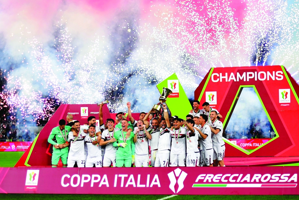 Bologna's Riccardo Orsolini lifts the trophy as he celebrates with teammates after winning the Coppa Italia. — Reuters