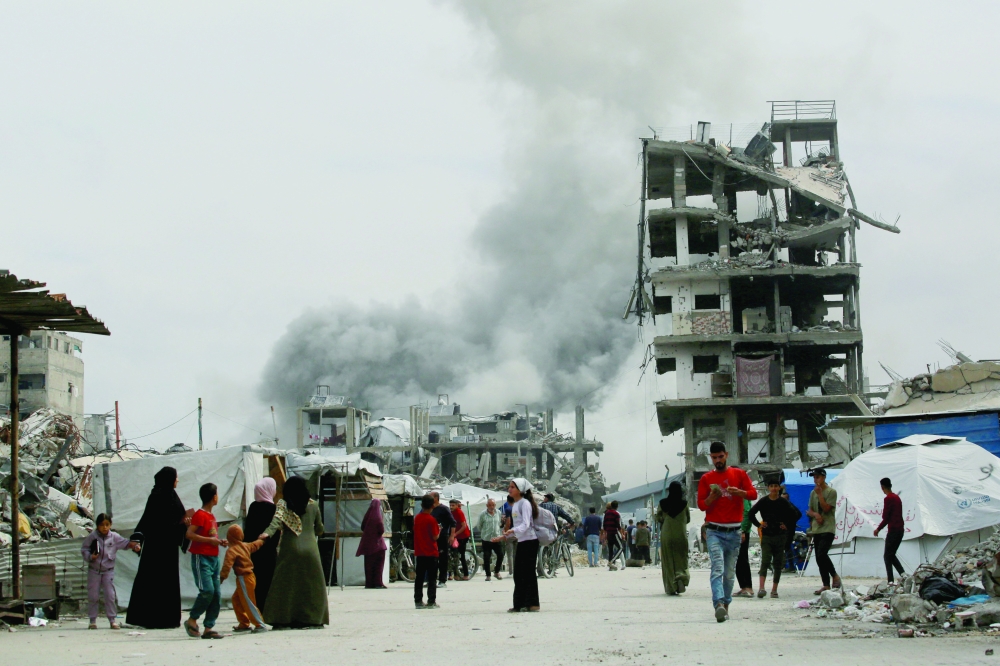 Palestinians run for cover as an Israeli strike hits homes in Jabalia, in the northern Gaza. — AFP