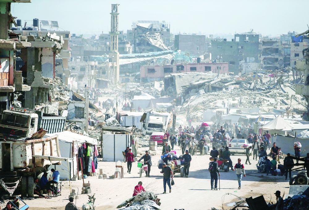 Palestinians make their way with belongings as they fled their homes, after Israeli air strikes, in Gaza. — Reuters
