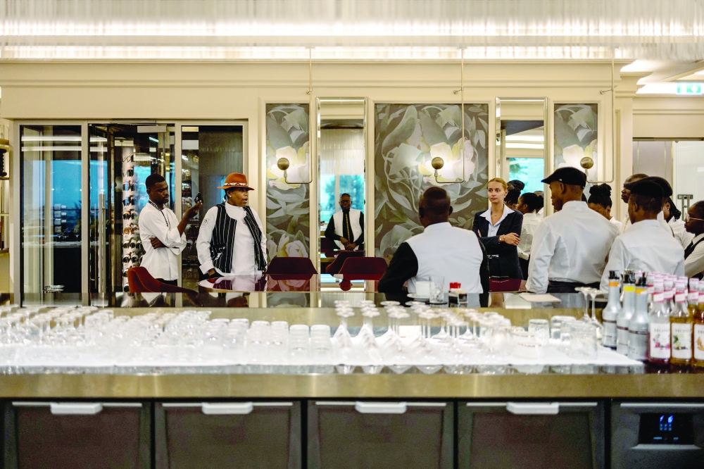 Franco Beninese Chef Georgiana Viou (2nd R) of the one-star Michelin Restaurant Rouge at the Margaret Hôtel Chouleur in Nimes, France, briefs the staff before the service at the restaurant L’Ami at the Sofitel Hotel in Cotonou, on January 12, 2025. 

