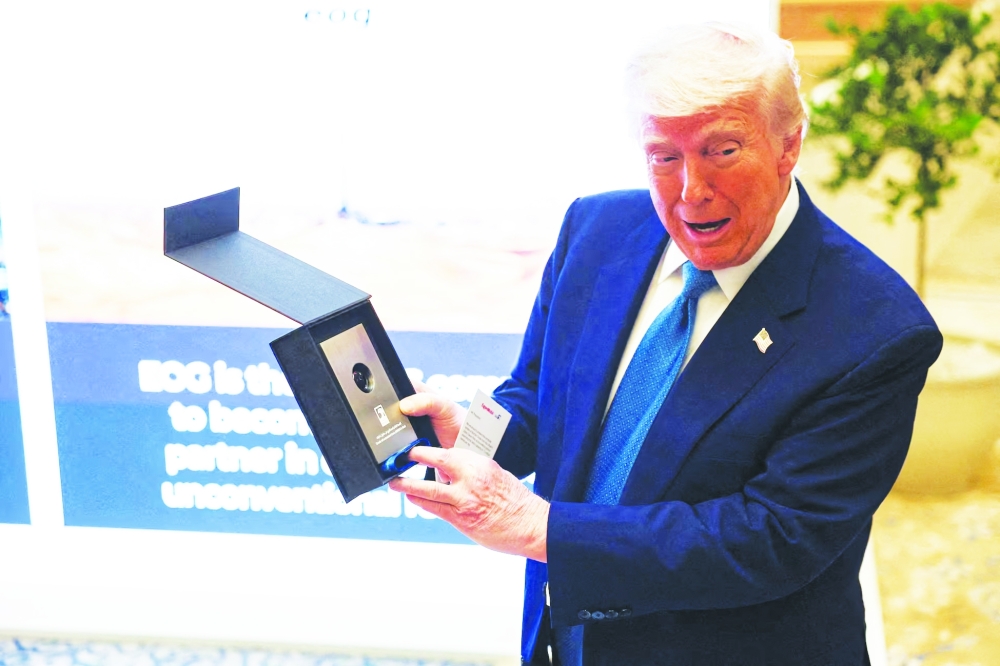 US President Donald Trump holds a sample of oil that he was gifted as he attends a business forum at Qasr Al Watan during the final stop of his Gulf visit, in Abu Dhabi, United Arab Emirates, last Friday. — Reuters