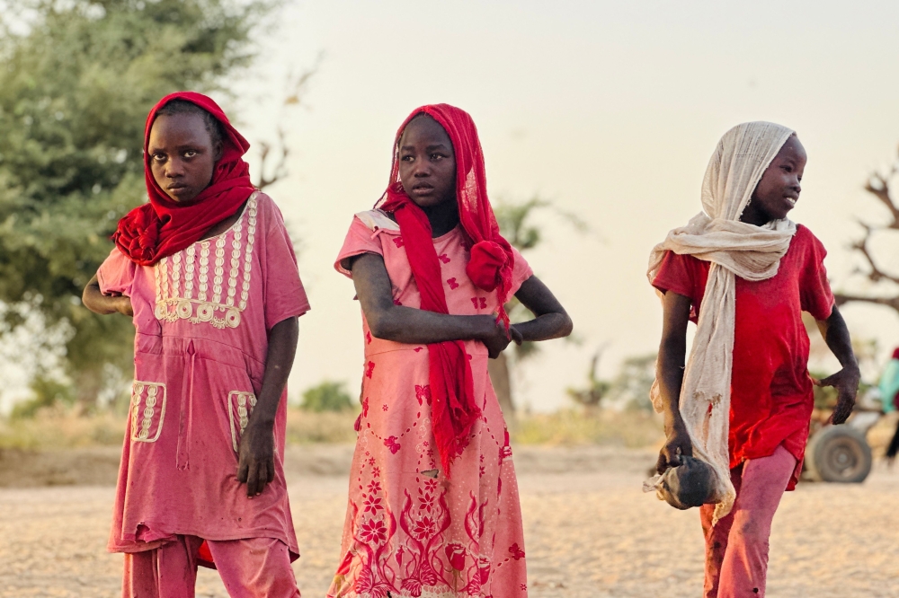 Displaced Sudanese girls look on as they gather near the town of Tawila in North Darfur. — AFP