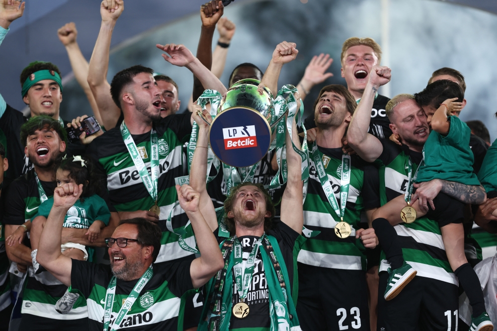 Sporting CP's Morten Hjulmand lifts the trophy as he celebrates with teammates after winning the Primeira Liga. — Reuters