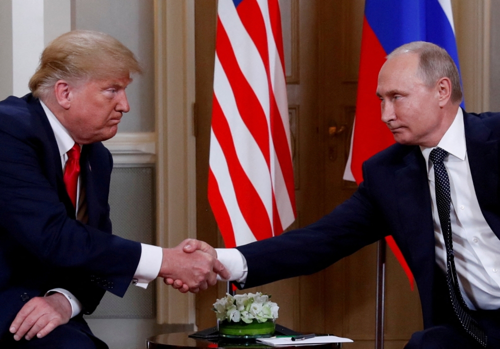 US President Donald Trump and Russia's President Vladimir Putin shake hands as they meet in Helsinki, Finland. — Reuters file photo