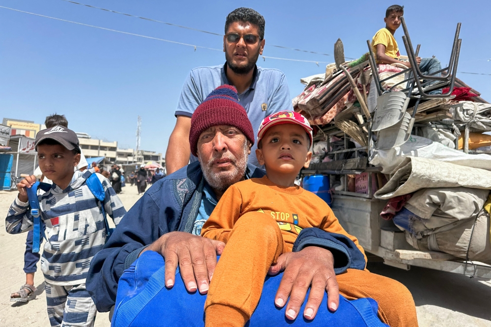 Palestinians move with their belongings following Israeli evacuation orders for Khan Yunis on May 19, 2025. Israel said it will "take control" of the whole of Gaza, where rescuers reported more than 50 killed in Israeli strikes as the military pressed a newly intensified campaign. (Photo by AFP)
