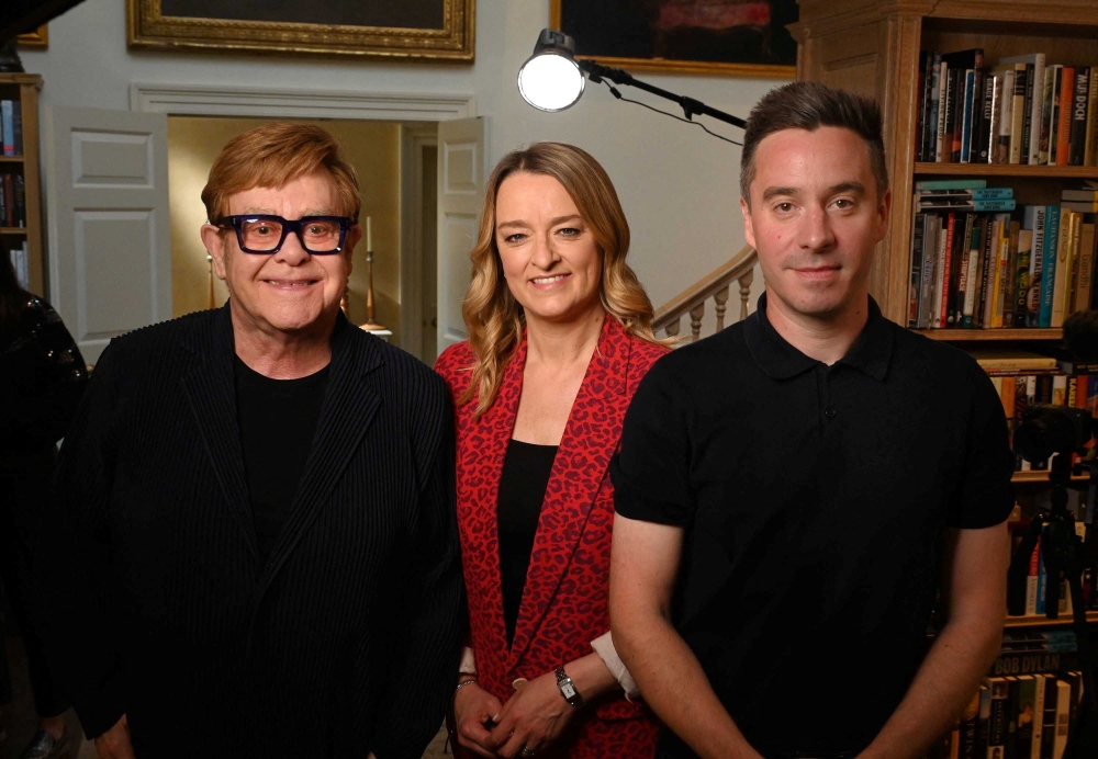 Sir Elton John and playwright/writer James Graham pose for a picture with Laura Kuenssberg on the day of an interview, near London, Britain May 17, 2025. Jeff Overs/BBC/Handout via REUTERS    THIS IMAGE HAS BEEN SUPPLIED BY A THIRD PARTY. NO RESALES. NO ARCHIVES. MANDATORY CREDIT. NOT FOR USE MORE THAN 21 DAYS AFTER ISSUE.
