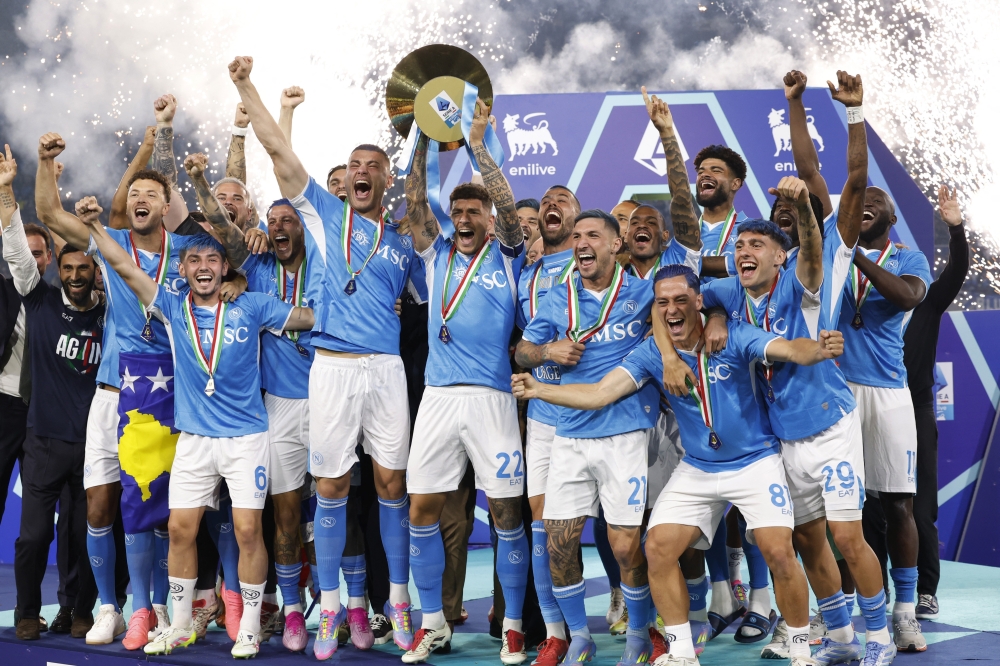 Napoli's Giovanni Di Lorenzo lifts the trophy as he celebrates winning Serie A with teammates. — Reuters