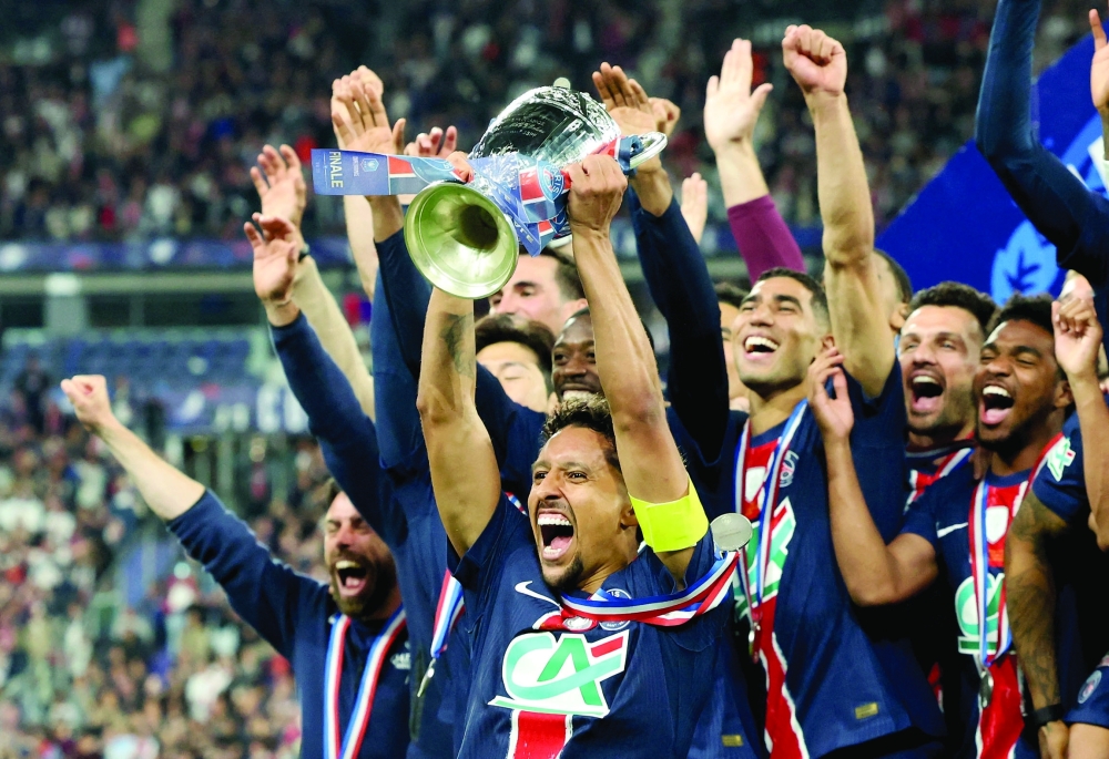 Paris St Germain's Marquinhos lifts the trophy as he celebrates with teammates after winning the Coupe de France. — Reuters