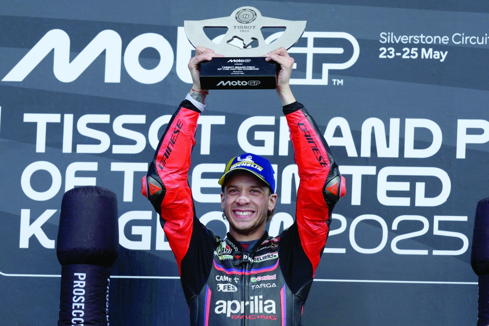 Winner, Aprilia Racing team's Italian MotoGP rider Marco Bezzecchi celebrates with his trophy on the podium after the MotoGP British Grand Prix at Silverstone circuit in Northamptonshire, central England. — AFP