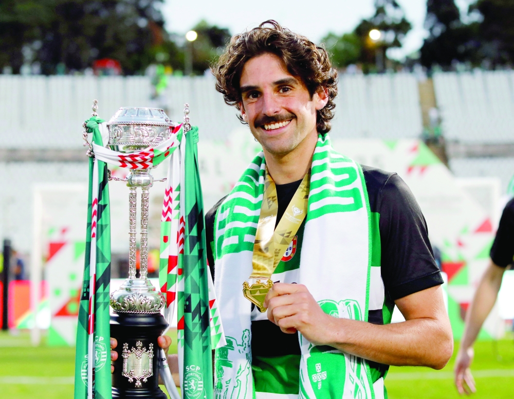 Sporting CP's Francisco Trincao celebrates winning the Taca de Portugal with the trophy. —  Reuters