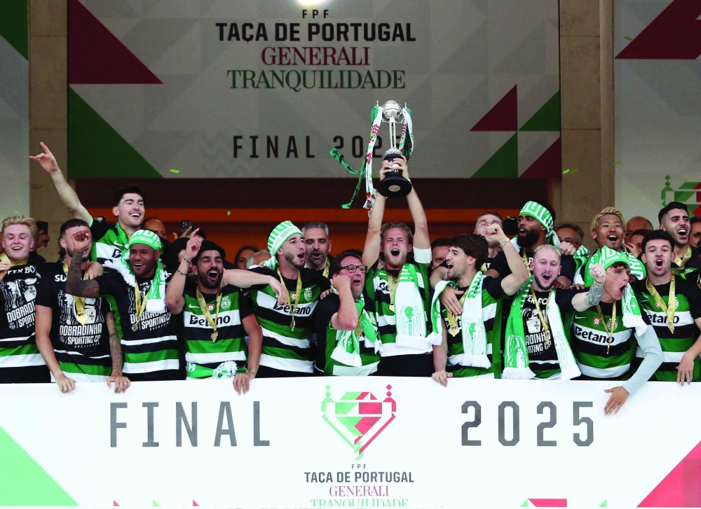 Sporting CP's Morten Hjulmand lifts the trophy as he celebrates with teammates after winning the Taca de Portugal. — Reuters