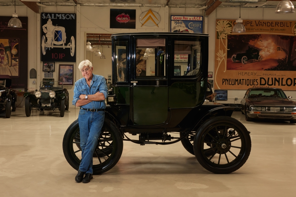 Jay Leno with a restored 1909 Baker Electric at a facility for his large automobile collection in Burbank, Calif., April 29, 2025. (Maggie Shannon/The New York Times)