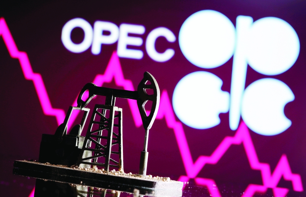 A 3D printed oil pump jack is seen in front of displayed stock graph and Opec logo in this illustration picture. — Reuters