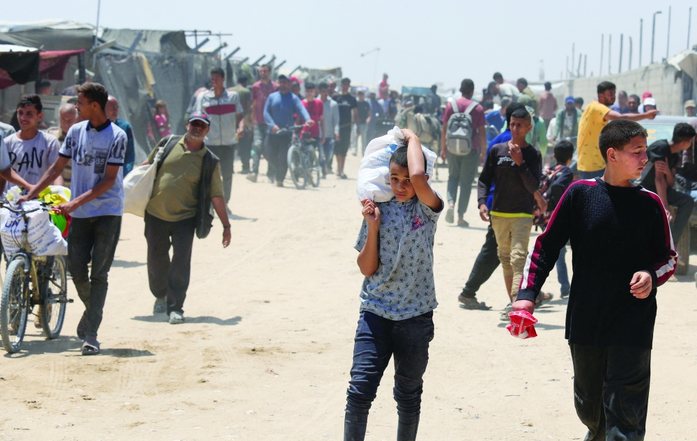 A Palestinian carries an aid supply he received from Gaza Humanitarian Foundation, in Khan Yunis. — Reuters