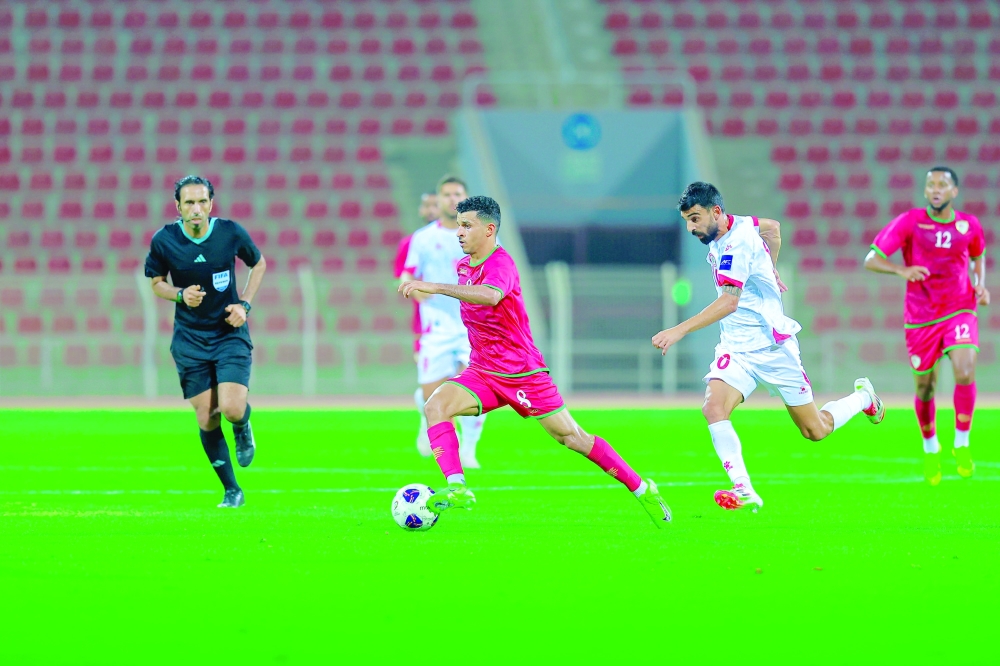 Oman player controls the ball