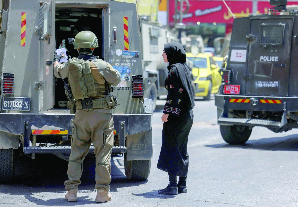 Israeli forces detain a Palestinian woman working in the occupied West Bank. — AFP