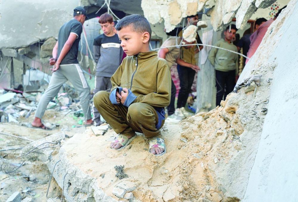 A Palestinian boy looks on next to damage at the site of an Israeli strike on a house, in Jabalia, northern Gaza Strip, on Thursday. - Reuters