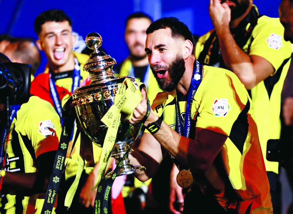 Al Ittihad's Karim Benzema celebrates with the trophy. — Reuters