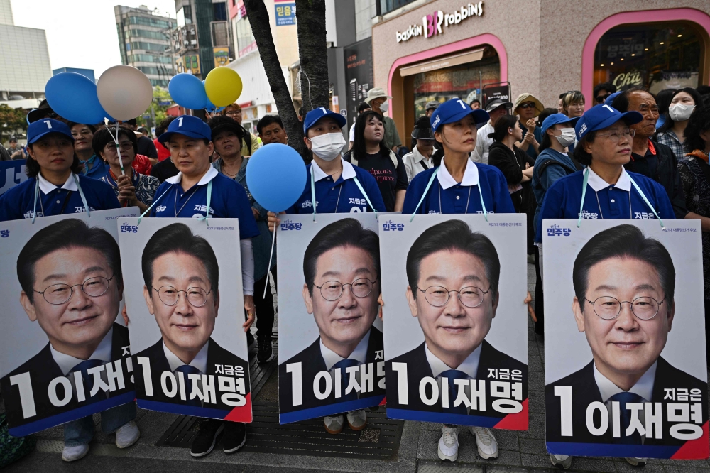 Supporters of presidential candidate Lee Jae-myung hold placards as they attend a political rally, in Seoul. — AFP