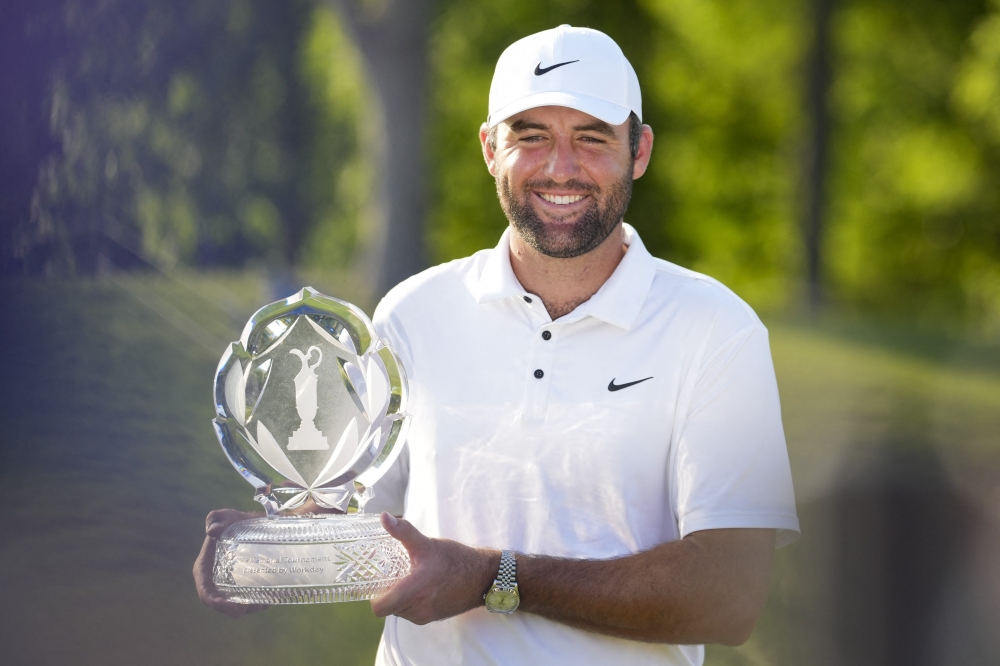 Scottie Scheffler poses for photos with the tournament trophy after winning the Memorial Tournament. — Reuters