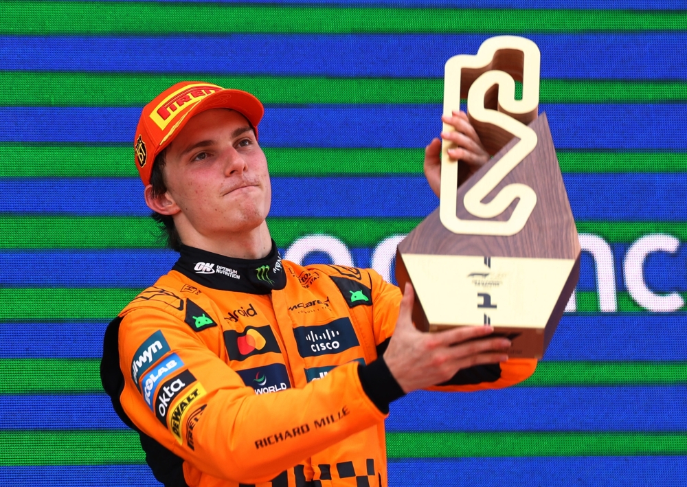 McLaren's Oscar Piastri celebrates on the podium with a trophy. — Reuters