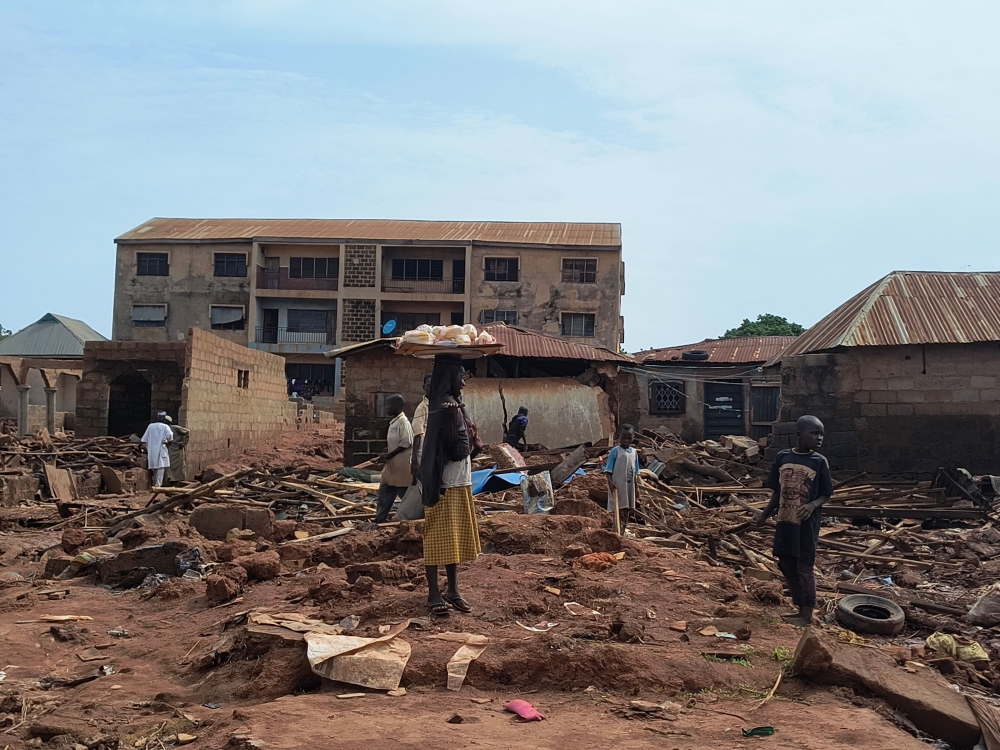 A woman stands next to debris from damaged buildings in Mokwa. — AFP 
