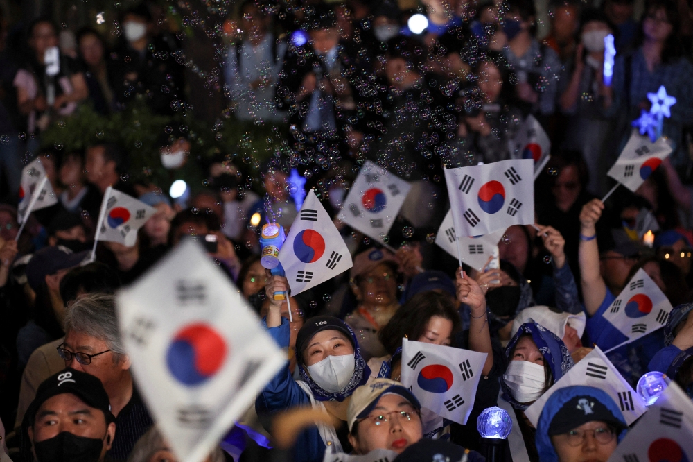 Supporters wait for Lee Jae-myung, near the National Assembly in Seoul. — Reuters