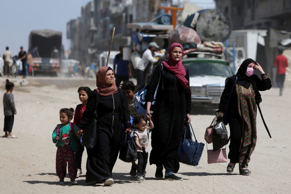 Palestinians carry their belongings as they flee their homes after the Israeli army issued evacuation orders from the center Khan Younis, in the southern Gaza Strip, June 3, 2025. REUTERS/Hatem Khaled     TPX IMAGES OF THE DAY