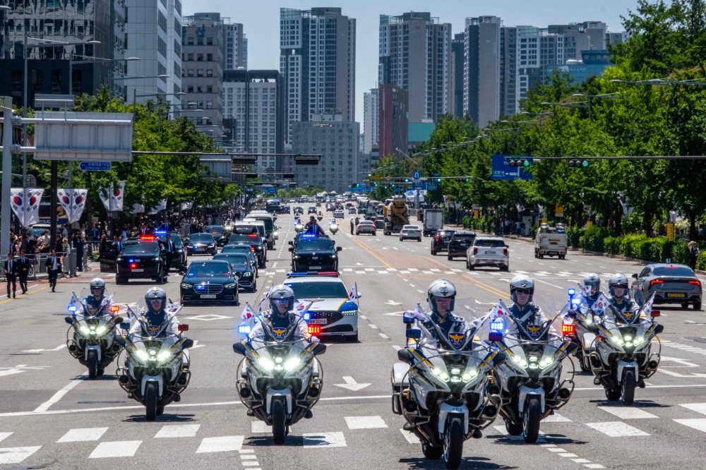 The motorcade transporting South Korea's President Lee Jae-myung is seen en route to the presidential office, in Seoul. — AFP