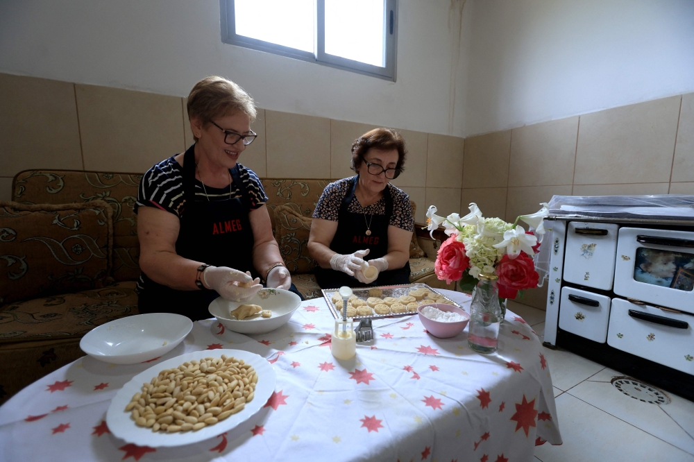 Eftali Qerimi (L) and Odeta Nasi, prepare traditional Albanian sweets with rose water in their workshop in Permet, some 250km Southwest of the capital Tirana, on May 28, 2025.  In Permet, deep in the spectacular Vjosa Valley of southern Albania, roses rule supreme, whether used to make perfumes, flavoured water or the Turkish delight sought out by thousands of sweet-toothed tourists.  (Photo by Adnan Beci / AFP)

