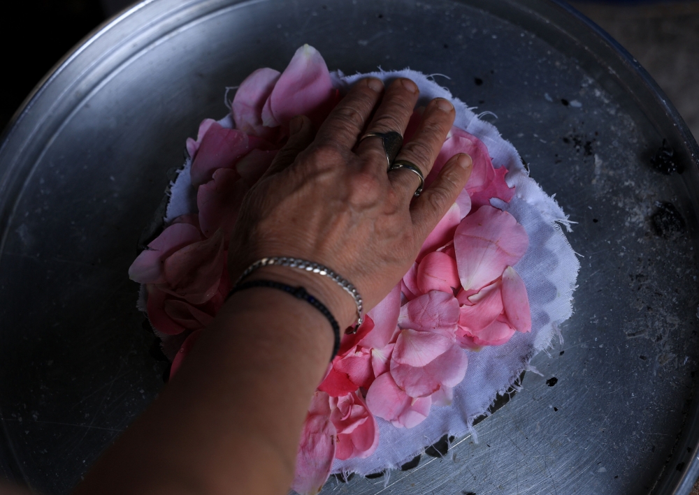 Ariana Nikolla prepares rose water in the traditional way in Permet, some 250km Southwest of the capital Tirana, on May 28, 2025.  In Permet, deep in the spectacular Vjosa Valley of southern Albania, roses rule supreme, whether used to make perfumes, flavoured water or the Turkish delight sought out by thousands of sweet-toothed tourists.  (Photo by Adnan Beci / AFP)

