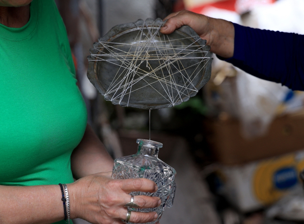 Ariana Nikolla (L) and Resmie Tuci prepare rose water in the traditional way in Permet, some 250km Southwest of the capital Tirana, on May 28, 2025.  In Permet, deep in the spectacular Vjosa Valley of southern Albania, roses rule supreme, whether used to make perfumes, flavoured water or the Turkish delight sought out by thousands of sweet-toothed tourists.  (Photo by Adnan Beci / AFP)

