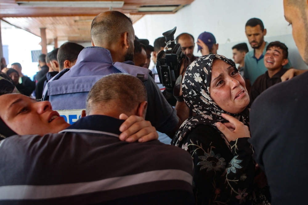 Relatives mourn the death of three Palestinian journalists reportedly killed in Israeli bombardment in the yard of the Ahli Arab Hospital, in Gaza City on Thursday. — AFP