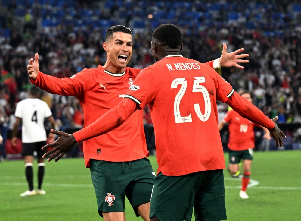 Soccer Football - Nations League - Semi Final - Germany v Portugal - Allianz Arena, Munich, Germany - June 4, 2025 Portugal's Cristiano Ronaldo celebrates scoring their second goal with Portugal's Nuno Mendes REUTERS/Angelika Warmuth     TPX IMAGES OF THE DAY
