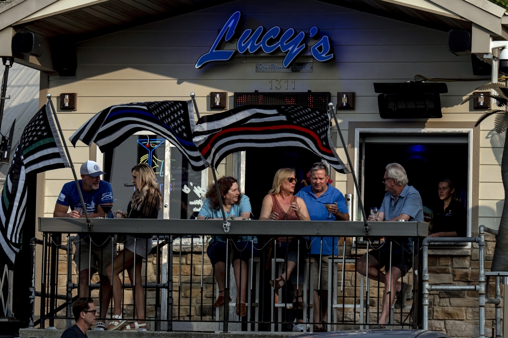 Patrons have drinks outside at Lucy's At The Lake in Lake Ozark, Mo. — The New York Times