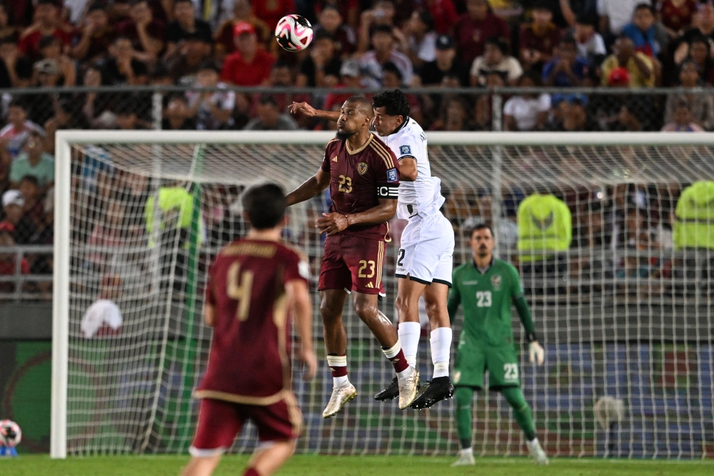 Venezuela's forward #23 Salomon Rondon and Bolivia's defender #02 Diego Arroyo fight for the ball. — AFP