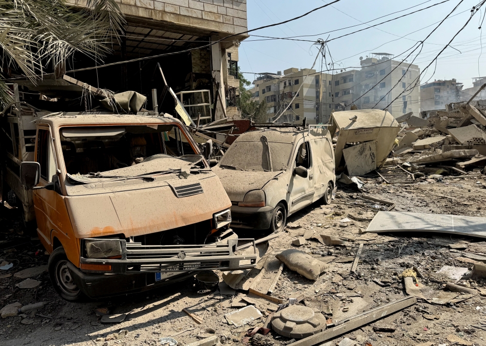 Damaged vehicles and debris lie in, in Beirut's southern suburbs. — Reuters